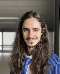 a man with long hair and a blue tie